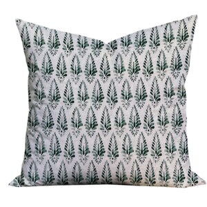 Puede incluir: Una almohada blanca con un patr&oacute;n de hojas verdes. La almohada est&aacute; hecha de una tela suave y c&oacute;moda y tiene un brillo sutil.