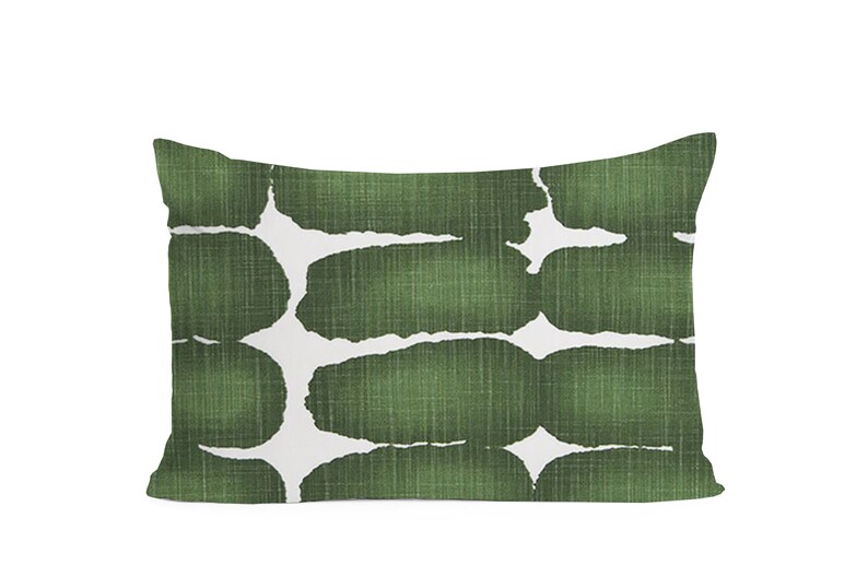 May include: A green and white rectangular cushion with an abstract pattern of green shapes on a white background.