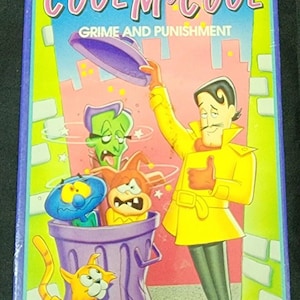 Può includere: Una videocassetta VHS per i fumetti animati "Cool McCool". La copertina presenta personaggi dei cartoni animati, tra cui un uomo con un cappotto giallo, un gatto e altre figure animate. Il titolo è in grandi lettere colorate.