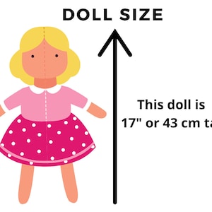 K&ouml;nnte beinhalten: Eine Puppe in einem rosa-wei&szlig; gepunkteten Kleid mit blonden Haaren. Die Puppe ist 17" oder 43 cm gro&szlig;.