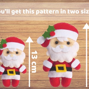 Puede incluir: Dos adornos de fieltro de Pap&aacute; Noel con trajes rojos y blancos, cinturones negros con hebillas amarillas y detalles de acebo verde. El texto dice: You'll get this pattern in two sizes. Las flechas indican alturas de 13 cm y 18 cm.
