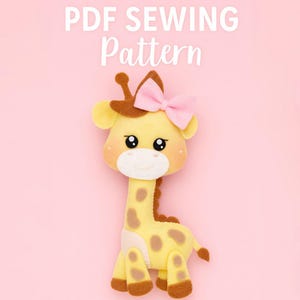 May include: A handmade yellow giraffe plushie with brown spots, a brown crown, and a pink bow. The text "PDF SEWING Pattern" is displayed in white at the top. The background is a solid pink.