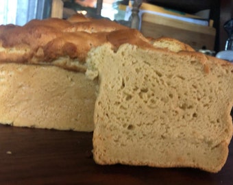 May include: A loaf of freshly baked bread, sliced open to reveal a soft, airy crumb. The bread is a light golden brown color and has a slightly crusty exterior.