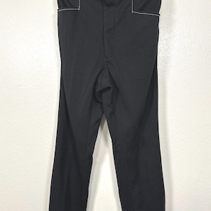 May include: Black pants with white stitching detail. The pants have a straight leg and a high waist.