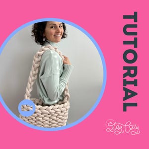 May include: A beige, chunky-knit tote bag with a braided strap is held by a person wearing a light blue sweater. The bag is set against a pink background with the word "TUTORIAL" in green and the text "Stay Cozy".