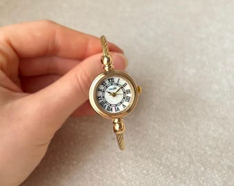 Gouden vintage polshorloge, wijzerplaat parelmoer, minimalistische Romeinse cijfers