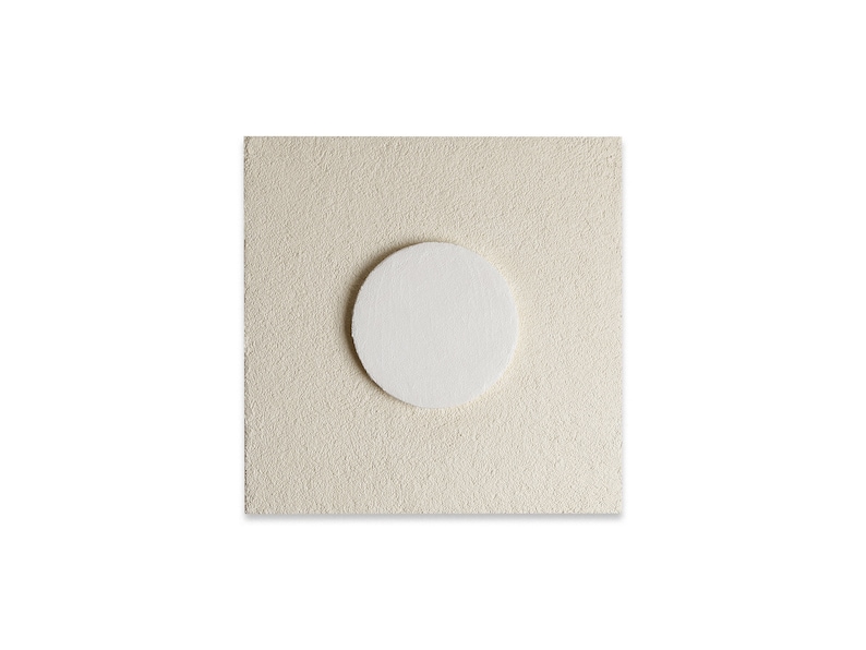 May include: A white circle on a beige textured background.