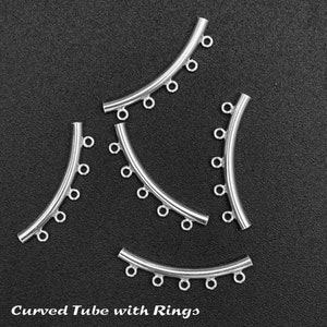 May include: Five silver curved tubes with rings. Each tube has five rings attached to it. The tubes are arranged in a semi-circle shape. The background is black. Curved Tube with Rings.