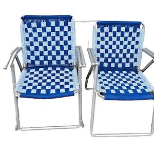 May include: Two blue and white checkered folding chairs with silver frames. The chairs are made of a woven material and have a simple design.