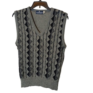 May include: Gray sleeveless sweater vest with a black geometric pattern. The vest has a V-neck and is made of a knit fabric.
