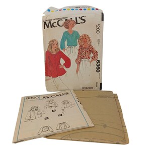 May include: A vintage McCall's sewing pattern packet featuring illustrations of women's tops. The packet is labelled "6360" and has a price tag of £1.60. The packet is accompanied by pattern instructions and additional pattern pieces.