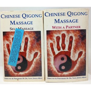 May include: Two VHS tapes titled "Chinese Qigong Massage." One is "Self Massage" and the other is "With a Partner." Each tape cover features a red handprint over a yin-yang symbol.