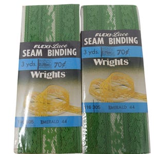 May include: Two rolls of green Flexi-Lace seam binding. Each roll is labeled with the text "Flexi-Lace Seam Binding" and "3 yds." The packaging also includes the brand name "Wrights" and the color "Emerald 44".