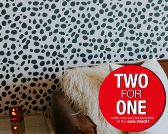 May include: A white wall with a black and white pebble pattern stencil design. The stencil is applied to the wall, creating a modern and stylish look. The text "TWO FOR ONE" is in a red circle, with the words "order one and receive two of the same stencil!" below.