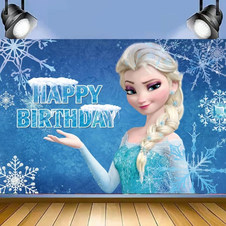 May include: A blue and white backdrop with a cartoon image of Elsa from Frozen. The backdrop has the words "Happy Birthday" on it.