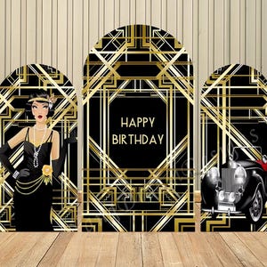 Puede incluir: Un telón de fondo de tres paneles con temática art déco en negro y dorado. Los paneles presentan una flapper, un coche antiguo y las palabras "Happy Birthday". El telón de fondo está sobre un fondo de madera.