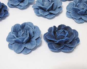 Könnte beinhalten: Eine Sammlung von blauen Jeansstoffblumen. Die Blumen sind alle gleich groß und gleich geformt und haben ein leicht gekräuseltes Aussehen.