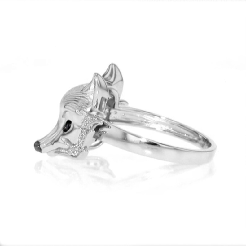 Peut inclure: Une bague en argent avec un motif de t&ecirc;te de renard. Le renard a une pierre pr&eacute;cieuse noire pour l'&oelig;il.