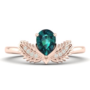 Może przedstawiać: Pierścionek z różowego złota z centralnym kamieniem szlachetnym w kształcie gruszki, w kolorze morskim. Pierścionek ma dekoracyjny, liściasty wzór z małymi, przezroczystymi kamieniami akcentującymi. Oprawa jest z polerowanego różowego złota.