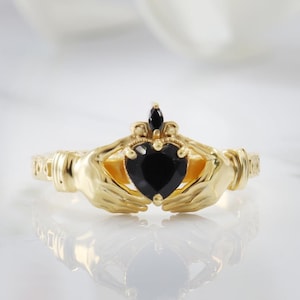 Anillo Claddagh con corazón de ónix negro y banda celta de oro amarillo de 14 quilates.