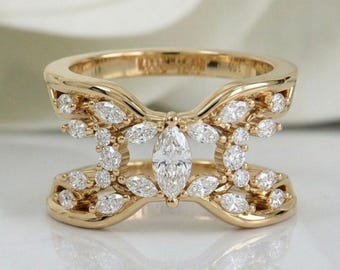 May include: A gold ring featuring a wide, open-work band design. The ring is adorned with numerous small, round, brilliant-cut diamonds and a single, prominent, marquise-cut diamond set horizontally in the center of the open space.