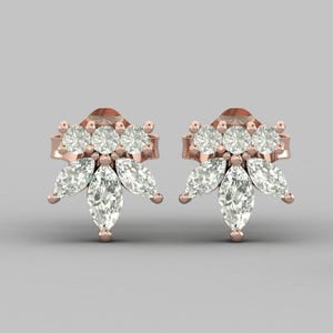 Puede incluir: Un par de pendientes de botón de oro rosa. Cada pendiente presenta un grupo de piedras preciosas claras redondas y en forma de marquesa. El diseño se asemeja a un arreglo floral, con las piedras preciosas dispuestas en un patrón simétrico.