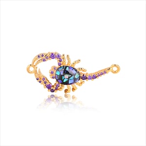 May include: Gold scorpion charm with purple gemstones and a blue and green abalone shell inlay.