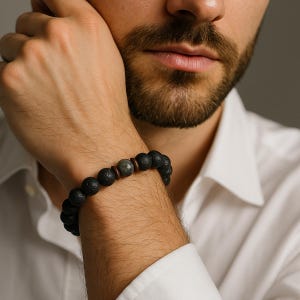 Könnte beinhalten: Ein schwarzes Armband aus Lavastein mit einem grauen Edelstein und braunen Holzperlen.