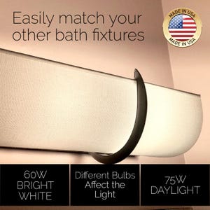 K&ouml;nnte beinhalten: Eine horizontale Badezimmerleuchte mit einem geschwungenen dunklen Metallrahmen und einem wei&szlig;en Stoffschirm. Der Text lautet: Easily match your other bath fixtures, 60W BRIGHT WHITE, Different Bulbs Affect the Light, 75W DAYLIGHT und ein MADE IN USA-Abzeichen.
