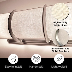 Könnte beinhalten: Ein hellfarbener Lampenschirm aus Leinen mit zwei silberfarbenen Metallhalterungen. Das Bild zeigt auch den Text "High Quality White Linen", "2 Silver Metallic Finish Brackets", "Easy to Install", "Handmade" und "Light Weight".