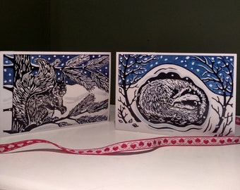 Pack of 8 linocut design Christmas cards featuring a sleeping badger and a red squirrel.