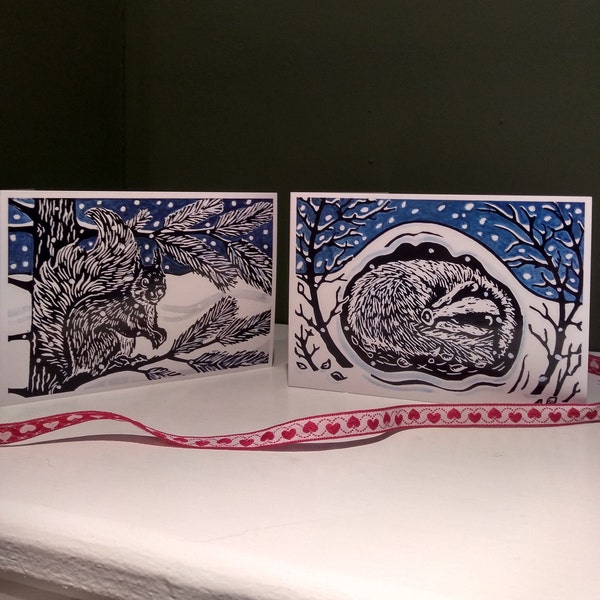 Pack of 8 linocut design Christmas cards featuring a sleeping badger and a red squirrel.