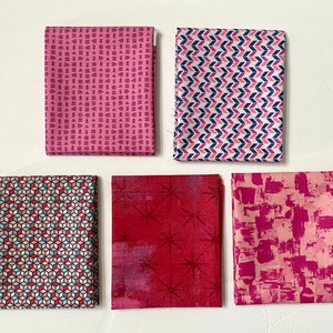 Può includere: Cinque campioni di tessuto in varie tonalità di rosa e rosso con motivi geometrici. I motivi includono un piccolo motivo geometrico rosa e bianco, un motivo chevron rosa e bianco, un motivo geometrico rosa e blu, un motivo a stella rosso e bianco e un motivo astratto rosa e bianco.