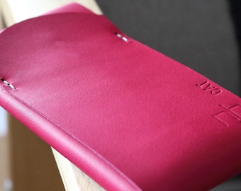 May include: A bright red leather phone case with white stitching and the word "Salt" embossed on the back.