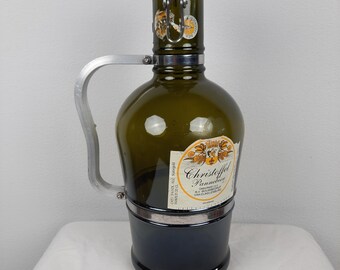 May include: A green glass bottle with a silver handle and a metal cap. The bottle has a label that reads "Christoffel Pannekoek" and is a vintage beer bottle.