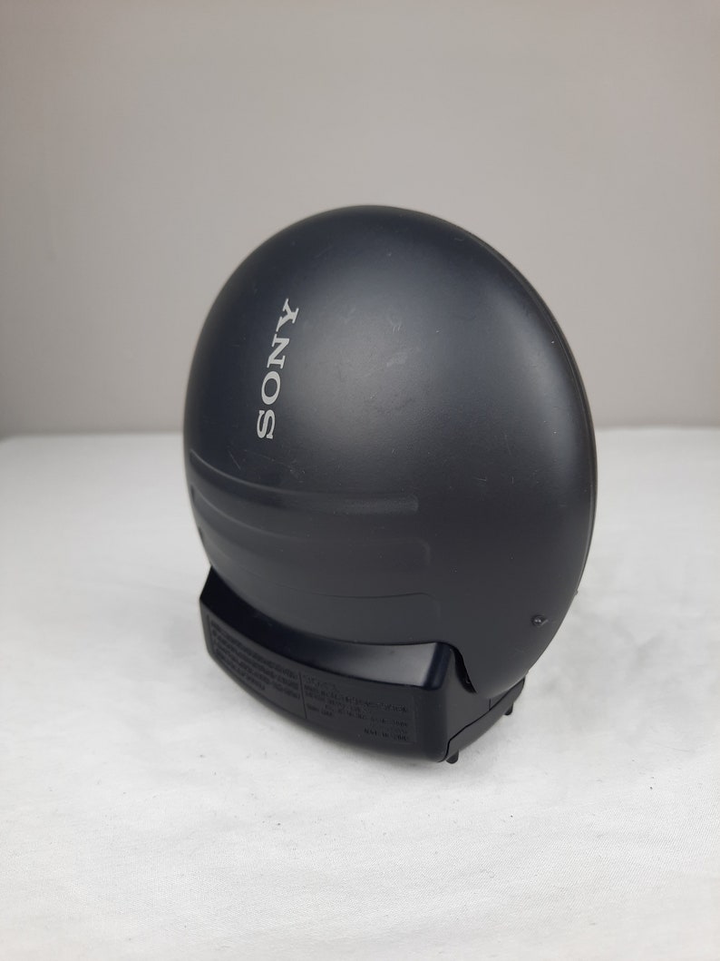 以下が含まれることがあります： 丸い形をした黒いソニーのCDプレーヤーで、前面に「SONY」と印刷されています。