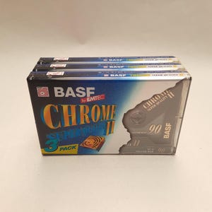May include: A stack of three BASF Chrome Super Quality II audio cassette tapes in a 3-pack box. The box features a blue and black design with the BASF logo and the text "Chrome Super Quality II". The tapes are labeled "90" for 90 minutes of recording time.