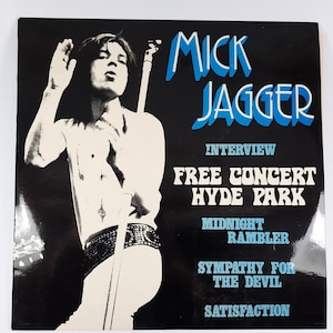 Pode incluir: Uma capa de álbum em preto e branco com Mick Jagger. A capa do álbum tem o texto "Mick Jagger" em azul e branco, juntamente com títulos de músicas como "Midnight Rambler" e "Satisfaction".