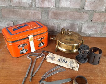 Estufa de camping vintage AIDA 220 de latón, pequeña, en caja de hojalata.
