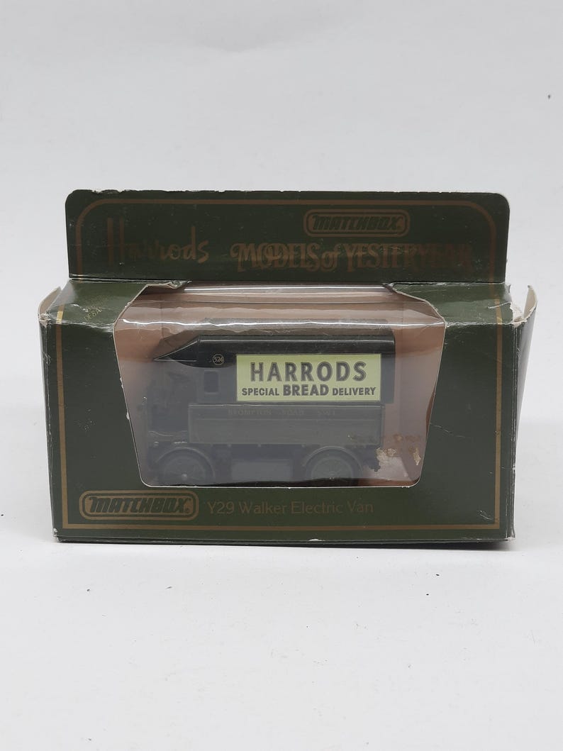 Puede incluir: Un veh&iacute;culo de juguete Matchbox Models of Yesteryear Y29 Walker Electric Van de color verde oscuro en su embalaje original. La furgoneta presenta un panel lateral crema con el texto HARRODS SPECIAL BREAD DELIVERY impreso en negro.
