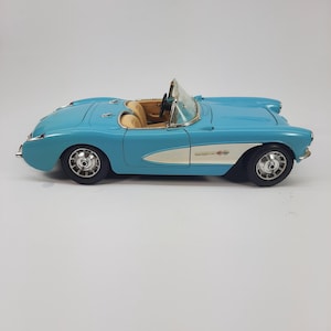 May include: A light blue vintage convertible car with a tan interior. The car has a white accent on the side and chrome wheels. The car is a classic model, likely from the mid-20th century.