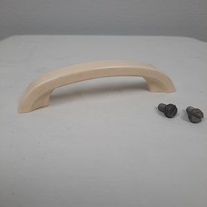 Puede incluir: Una manija de plástico blanco con dos tornillos plateados.