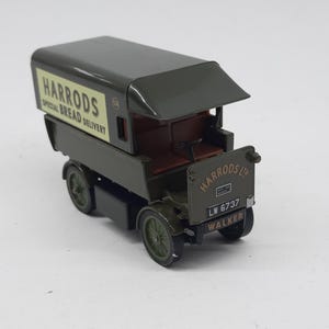 Puede incluir: Un cami&oacute;n de reparto de juguete de estilo antiguo en color verde oscuro con un panel lateral crema que presenta el texto HARRODS SPECIAL BREAD DELIVERY. El panel frontal muestra HARRODS LTD, la matr&iacute;cula LW 6737 y la palabra WALKER en negro.