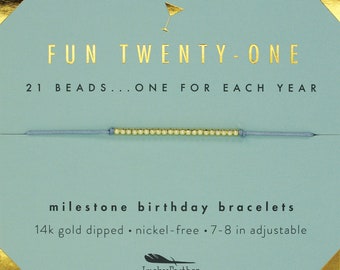 Peut inclure: Un bracelet bleu clair avec 21 perles dorées, une carte avec le texte "FUN TWENTY-ONE 21 BEADS...ONE FOR EACH YEAR" et le texte "milestone birthday bracelets 14k gold dipped nickel-free 7-8 in adjustable Lucky Feather".