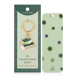 May include: A gold-colored keychain with a stack of books charm, a green and white bookmark, and a green card with the text "YOU ARE WHAT YOU READ." The keychain charm has the word "ADVENTURE" on it. The bookmark has star shapes.