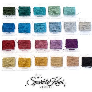 May include: A collection of twenty-three spools of metallic embroidery thread in various colors, including shades of green, blue, silver, red, pink, purple, gold, and black. Each spool is clear plastic. The text Sparkle Knot STUDIO is below.