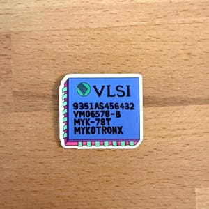 May include: A sticker depicting a blue VLSI chip design with white text and a green logo. The sticker has a white border with pink and green accents. The text includes "9351AS456432", "VM06578-B", "MYK-78T", and "MYKOTRONX".
