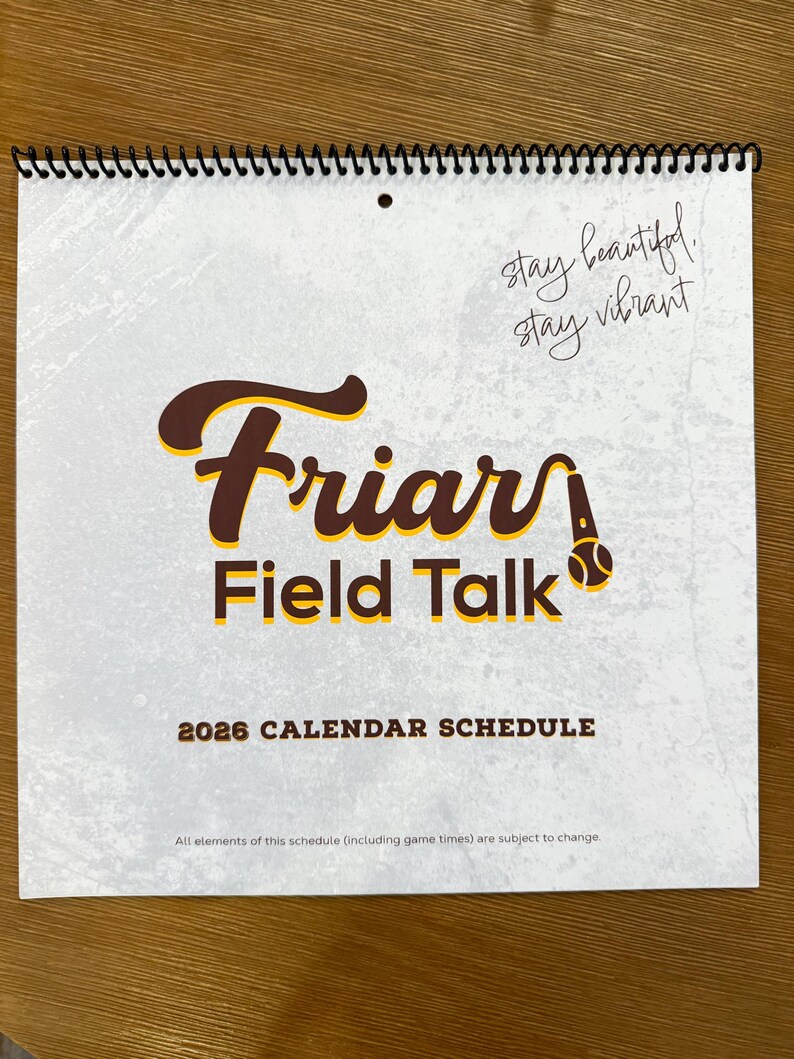 以下が含まれることがあります： 茶色と黄色の「Friars Field Talk」の文字が入った、スパイラル綴じのカレンダー。 2026年版で、「stay beautiful, stay vibrant」のフレーズが含まれています。 背景はテクスチャ加工されたオフホワイトです。