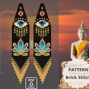 Puede incluir: Un par de aretes largos de cuentas con fondo negro, detalles dorados y un diseño de ojo azul. Los aretes también presentan un diseño de flor de loto rosa y azul. Los aretes se muestran sobre un fondo de puesta de sol con una estatua de Buda.