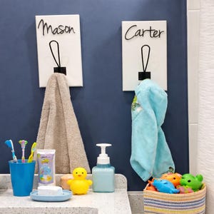 May include: A set of three ceramic mugs with a speckled, matte finish. The mugs are in shades of cream, light gray, and dark gray. Each mug has a simple, minimalist design and a rounded handle.